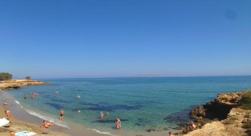 a group of people in the water at a beach at Blue Aegean Hotel & Suites in Gouves