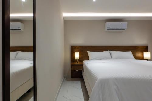 a bedroom with two beds and a mirror at Hotel 28 Cancun in Cancún