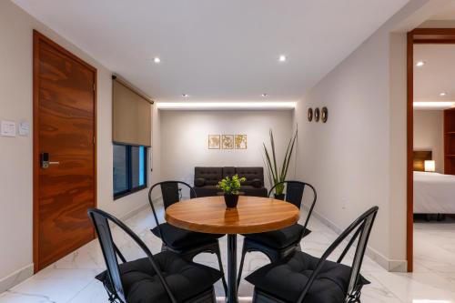 a dining room with a wooden table and chairs at Hotel 28 Cancun in Cancún
