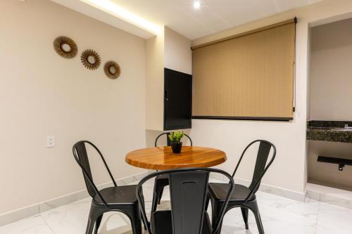 a dining room with a wooden table and black chairs at Hotel 28 Cancun in Cancún