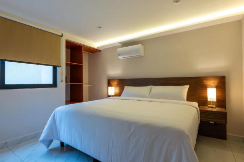 a bedroom with a white bed and a window at Hotel 28 Cancun in Cancún