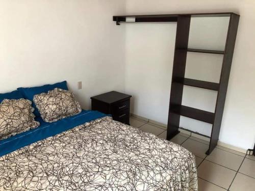 a bedroom with a bed and a book shelf at Recidencial Pacifico in Rincon de Guayabitos