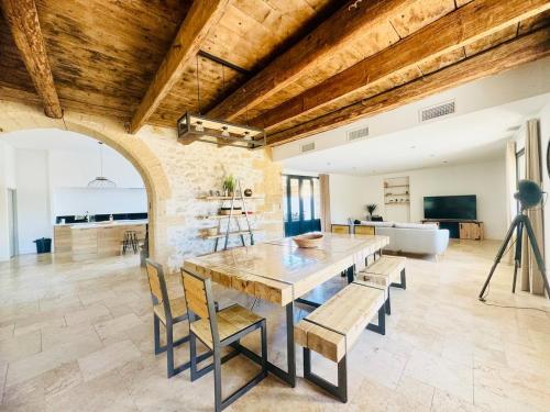 a dining room with a large wooden table and chairs at Les Rives du Parc Piscine 12 personnes in Lédenon