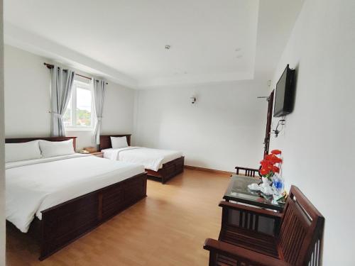 a hotel room with two beds and a television at Phú Quốc Center Hotel in Phu Quoc