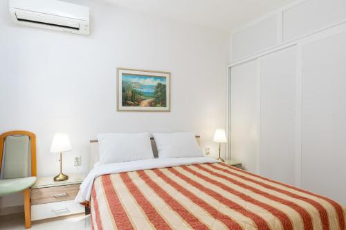 a bedroom with a large bed with a striped blanket at Apartment Luna i Lucky in Dubrovnik