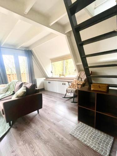 ein Wohnzimmer mit einer Couch und einigen Fenstern in der Unterkunft Chalet Het Hulstje 1 in Durbuy