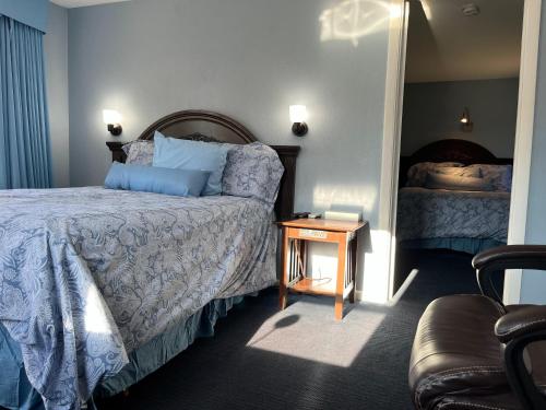 a bedroom with a bed and a table with a night stand at Hitching Post Motel in Cornwall