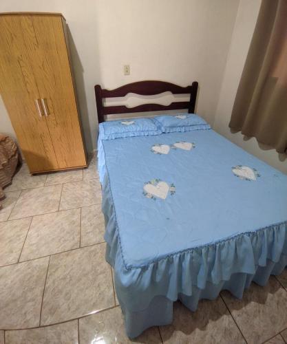 a bedroom with a bed with blue sheets and a cabinet at Casa da Marta Alto Caparaó in Alto Caparao