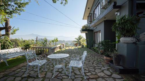 a patio with white chairs and a table with a view at No63 Amy's in Kandy