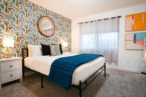 um quarto com uma cama com um cobertor azul em Lazy Palms em Tempe