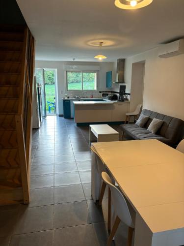 une cuisine et un salon avec un canapé et une table dans l'établissement Gîte Raynal, à Les Junies