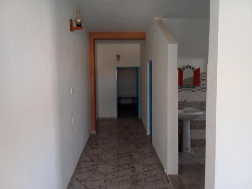 a hallway leading to a bathroom with a sink at dar fatma matmata in Matmata