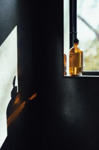 a bottle of whiskey sitting on a window sill at Beach Front Off-Grid Cabin on Kangaroo Island - Rae in Antechamber Bay