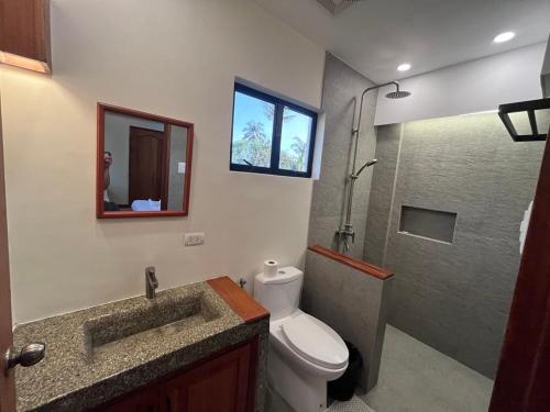 a bathroom with a toilet and a sink and a shower at Tabularasa - T Palawan in San Vicente