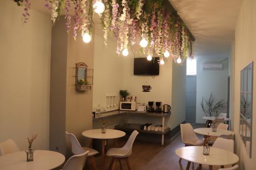 a restaurant with tables and chairs and flowers hanging from the ceiling at Mirandesa Garden in Porto
