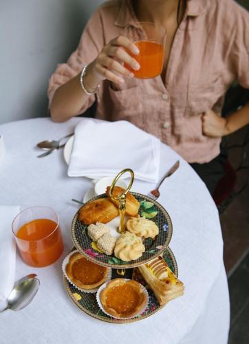 a woman sitting at a table with a plate of food at Shalai - Exclusive SPA and small gourmet hotel in Linguaglossa