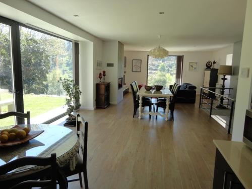 a dining room and living room with a table and chairs at Quinta Da Ribeira in Ponte de Lima