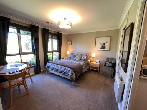 a bedroom with a bed and a table and chairs at The Red Letterbox in Blackheath