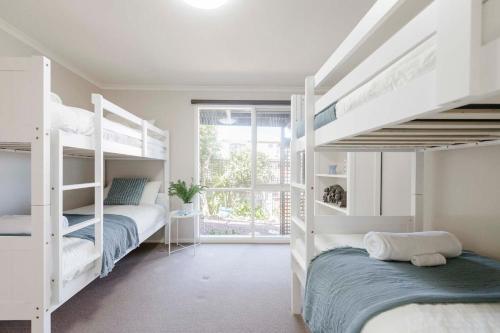 a bedroom with two bunk beds and a window at The Lookout Retreat in Anglesea