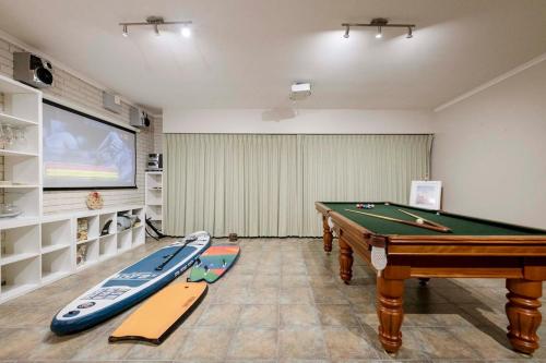 a living room with a pool table and a screen at The Lookout Retreat in Anglesea