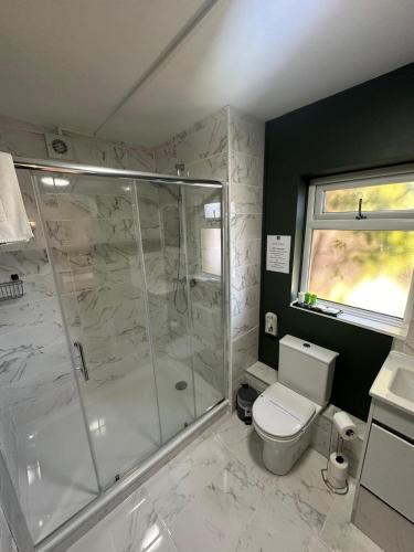 a bathroom with a shower and a toilet at The Cambridge Guest House by Tas in Cambridge