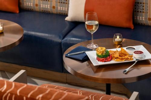 a table with a plate of food and a glass of wine at Crowne Plaza Virginia Beach Town Center by IHG in Virginia Beach