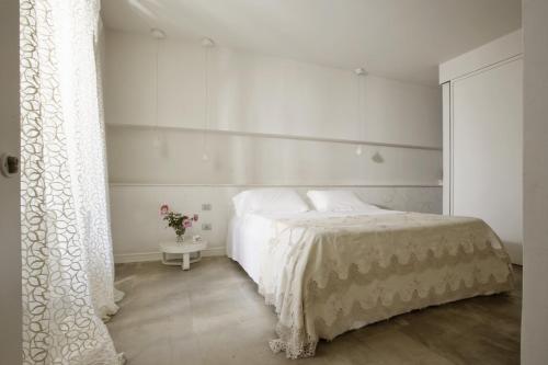 a bedroom with a white bed and a white curtain at Shalai - Exclusive SPA and small gourmet hotel in Linguaglossa
