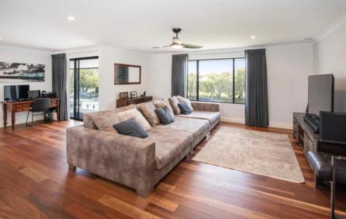 a living room with a couch and a television at Huge Luxury Busselton Jetty in Busselton