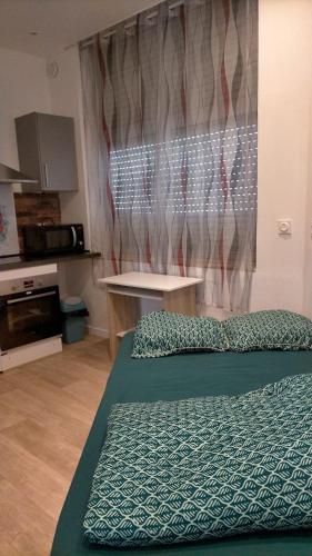 une chambre avec un lit, une table et une fenêtre dans l'établissement Le CosyWarm, à Calais