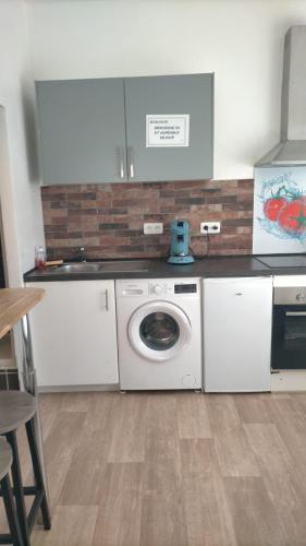 une cuisine avec un lave-linge et un comptoir dans l'établissement Le CosyWarm, à Calais