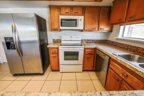 a kitchen with stainless steel appliances and wooden cabinets at Gorgeous Escape with a Pool in Fabulous Las Vegas in Las Vegas