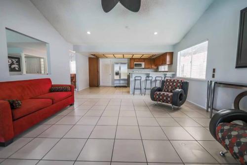 a living room with a red couch and a kitchen at Gorgeous Escape with a Pool in Fabulous Las Vegas in Las Vegas