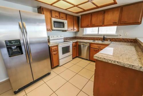 a kitchen with stainless steel appliances and wooden cabinets at Gorgeous Escape with a Pool in Fabulous Las Vegas in Las Vegas
