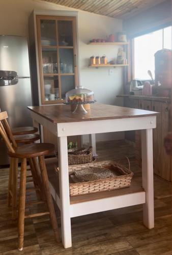 a kitchen island with a table in a kitchen at Chalé Home Sul de Minas in Pouso Alegre