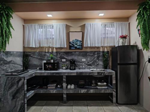 a kitchen with a counter and a refrigerator at Arenal Memories. in Fortuna