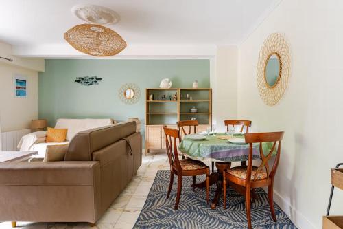 un salon avec un canapé, une table et des chaises dans l'établissement Côté Jardin - Terrasse, Calme et Cosy, à Deauville