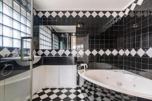 墨尔本Whistling Pines - Bayside Family Stay with Granny Flat的黑白浴室设有浴缸和水槽