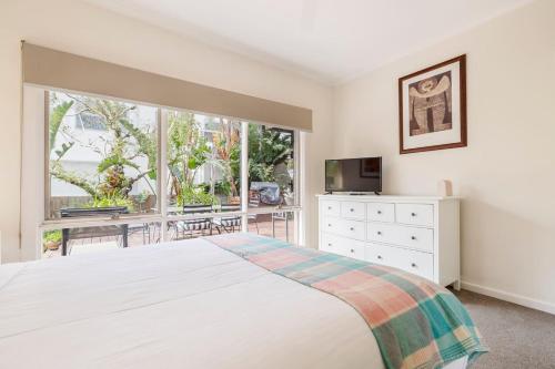 墨尔本Whistling Pines - Bayside Family Stay with Granny Flat的卧室里有一张白色的床和一扇大窗户