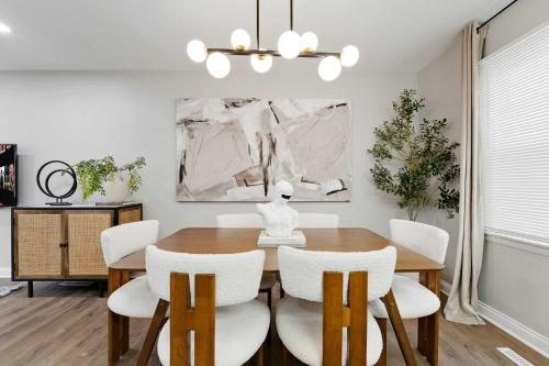 a dining room with a wooden table and white chairs at Spacious Family Getaway LCP Collection in Hanover Park