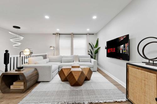 a living room with a white couch and a tv at Spacious Family Getaway LCP Collection in Hanover Park