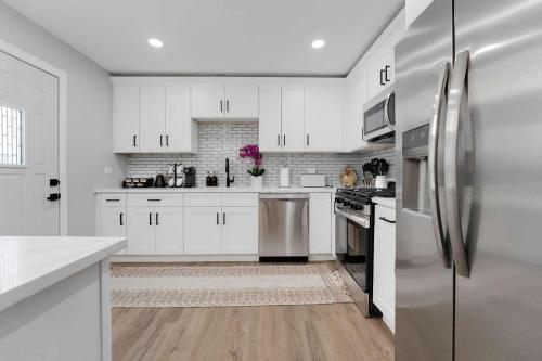 a kitchen with white cabinets and stainless steel appliances at Spacious Family Getaway LCP Collection in Hanover Park