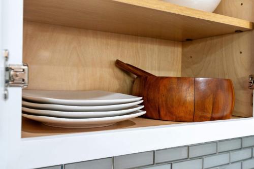 a shelf with a stack of plates in a kitchen at Spacious Family Getaway LCP Collection in Hanover Park