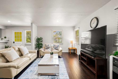 ein Wohnzimmer mit Sofa und Fernseher in der Unterkunft Spacious Retreat w Large Kitchen & Outdoor Patio in Pasadena