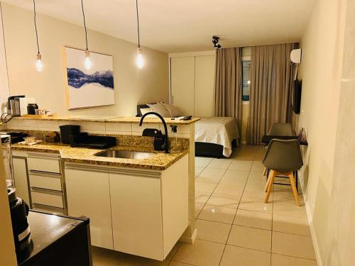 a kitchen with a sink and a room with a bed at Lapa Loft, estúdio vintage com total infraestrutura na Lapa, RJ in Rio de Janeiro