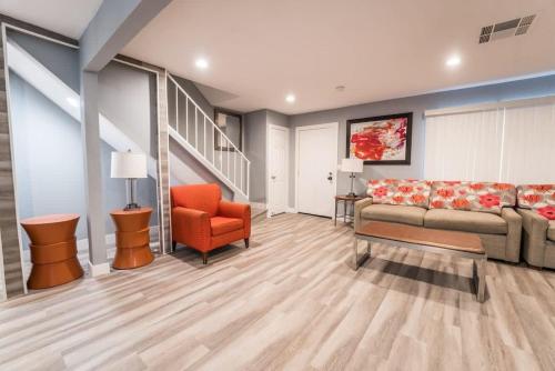 a living room with a couch and an orange chair at Luxury Living Just Steps from the Strip in Las Vegas