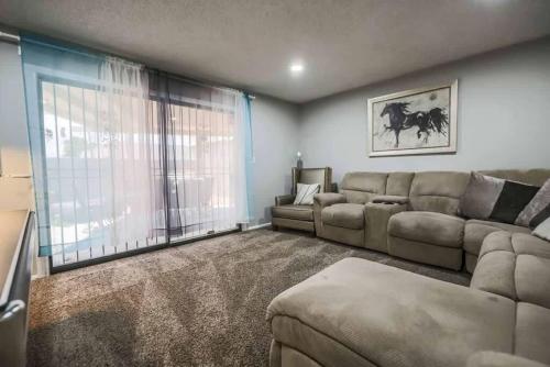 a living room with a couch and a large window at Modern Elegance in the Heart of Las Vegas in Las Vegas
