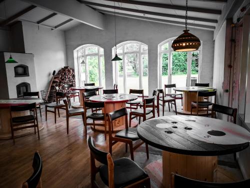 a dining room with tables and chairs and windows at Langeland Camping in Rudkøbing