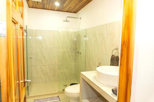 a bathroom with a shower and a sink and a toilet at Corcovado & Drake Inn in Drake