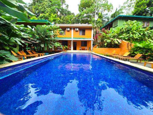 a large blue swimming pool in front of a house at Corcovado & Drake Inn in Drake