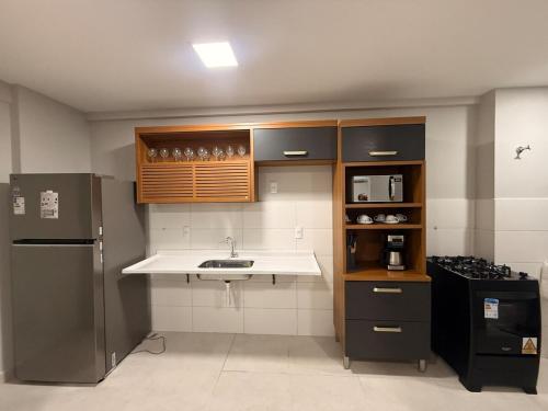 a kitchen with a sink and a refrigerator at Apt frente mar Ilheus-Ba 03 quartos in Ilhéus